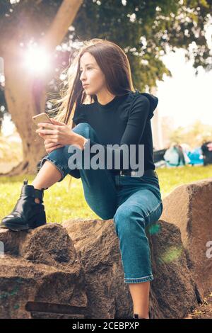 Young Woman using smartphone in park Stock Photo