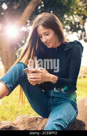 Young Woman using smartphone in park Stock Photo