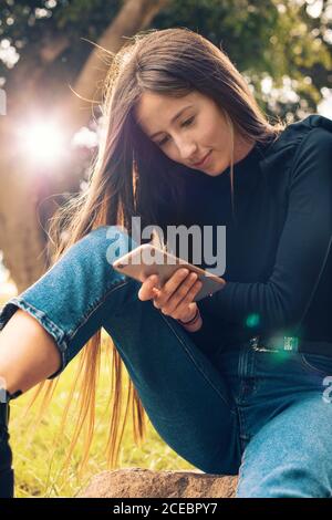Young Woman using smartphone in park Stock Photo