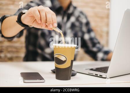 Crop man throwing sugar in coffee Stock Photo