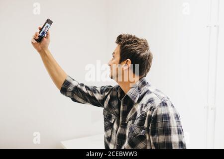 Smiling young man taking selfie on smartphone Stock Photo