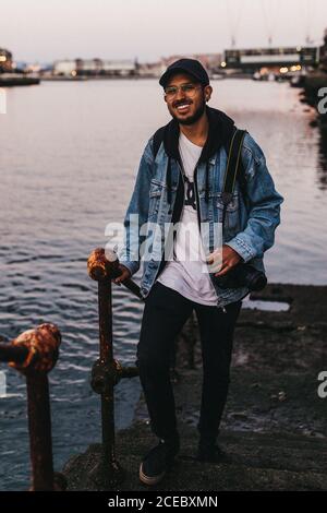 man with camera standing on embankment stairs Stock Photo