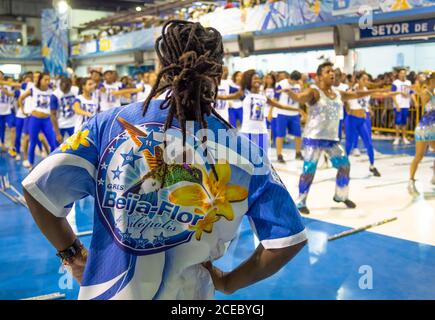 Rio de Janeiro, Brazil - February 13 2014: Back view of man with dreadlocks looking at people rehearsing dance in samba school Stock Photo
