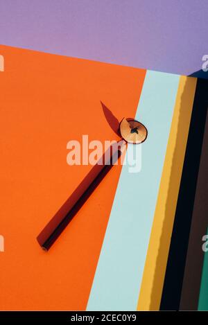 Pencil and shavings from sharpening, on colored striped papers background. Back to school concept Stock Photo