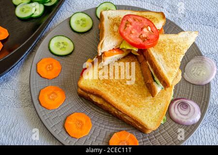 Beautifully arranged toasted Veg Cheese Sandwich on a round plate - Top Angle Shot. Stock Photo
