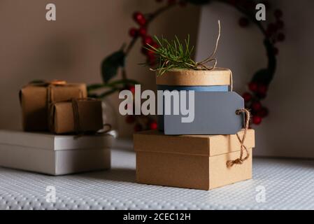 stacked Gifts boxs, wrapped in recycled paper and empty tag on white table Stock Photo