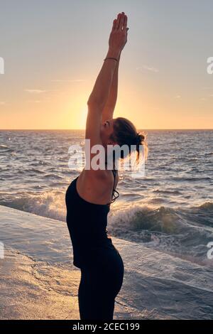 Young Woman doing yoga during sundown Stock Photo