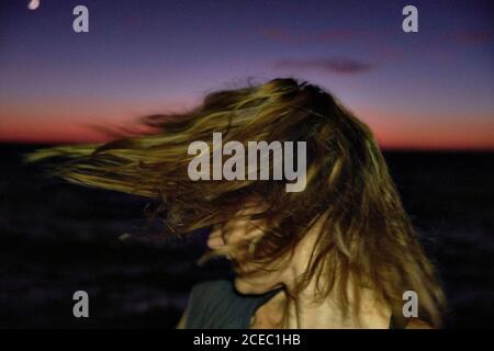 Woman shaking head against night sky and sea Stock Photo