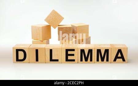 DILEMMA - word written on wooden cubes on a yellow background Stock Photo