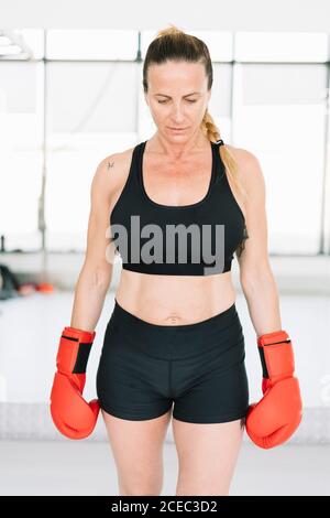 Adult Woman in boxing gloves standing Stock Photo