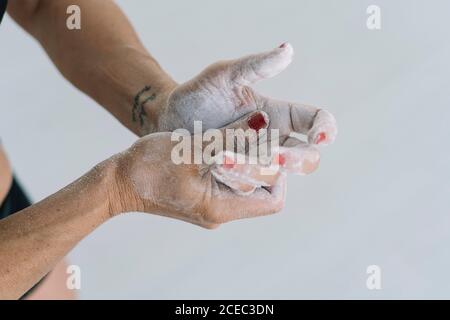 From above shot of crop Woman spreading chalk on hands while training in gym Stock Photo