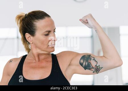 Tough muscular fit woman biceps workout exercise with dumbbell looking  away. Full body length portrait isolated on white studio background Stock  Photo - Alamy