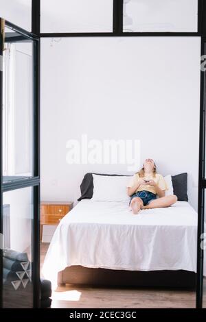 Relaxing Woman using phone on bed Stock Photo