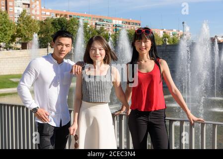 Asian people relaxing near fountain Stock Photo
