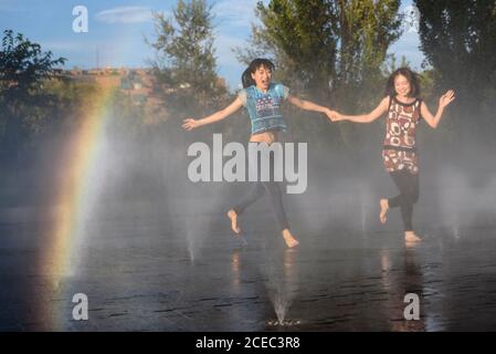 Asian women jumping on fountain water Stock Photo