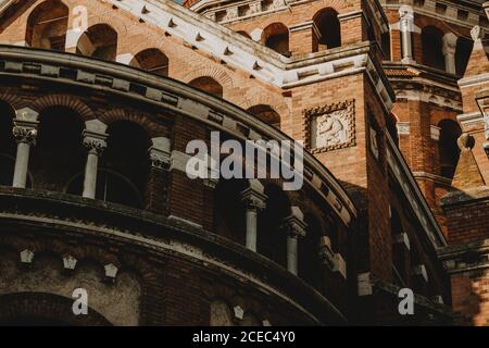 Detail of the red brick walls of Votive church in Szeged in south Hungary with the white relief of craftman during the summer morning Stock Photo