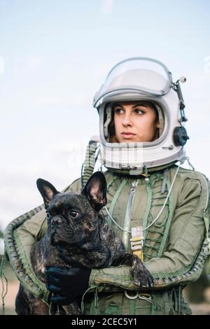 girl wearing old space helmet holding a dog Stock Photo