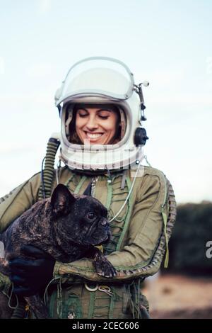 girl wearing old space helmet holding a dog Stock Photo