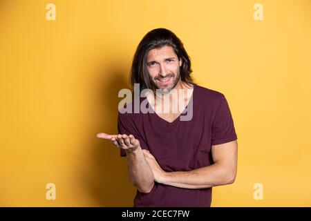 Handsome confident man posing on yellow wall Stock Photo