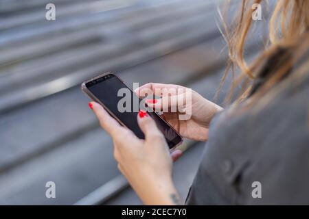Woman using smartphone on railway station Stock Photo