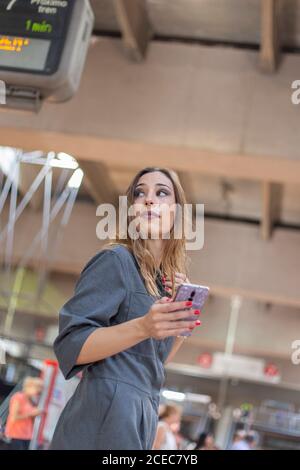 Woman using smartphone on railway station Stock Photo