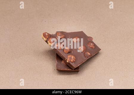broken chocolate with hazelnuts on beige background Stock Photo