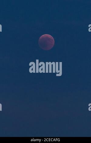 Amazing blood moon on dark night sky during eclipse in Madrid, Spain Stock Photo