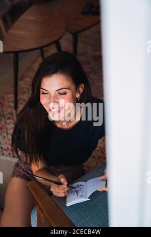 Young brunette Woman sitting in room Stock Photo