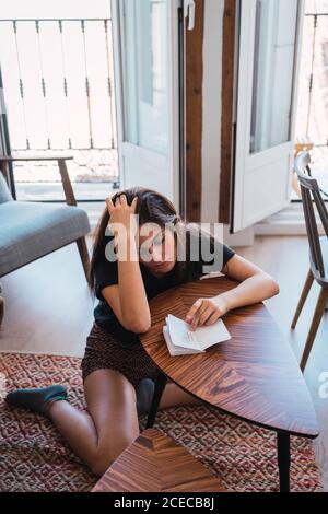 Young Woman sitting in room and writing in diary Stock Photo