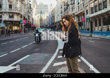 Woman using smartphone on road Stock Photo