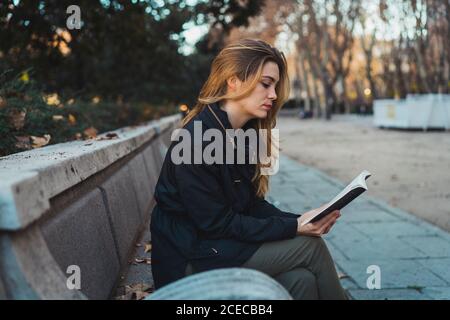 Woman reading book in park Stock Photo