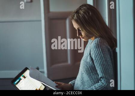 Woman sitting on the floor working with a laptop Stock Photo