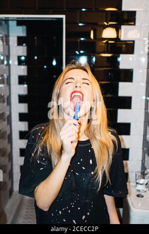 Blonde Woman brushing teeth Stock Photo
