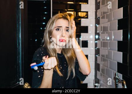 Blonde Woman brushing teeth Stock Photo