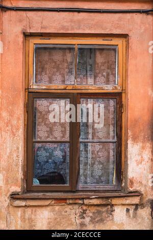 Crumbling wooden window on shabby wall of aged building in small town Stock Photo