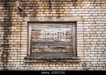 Boarded window on brick building Stock Photo