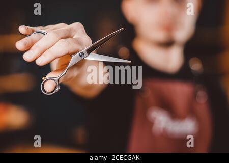 Barbershop Close-up of barber holds clip-on hair clipper Stock Photo