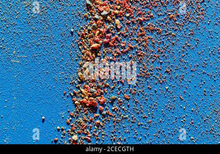 Abstract background of small multicolored pieces of chalk on blue paper Stock Photo