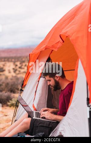 Traveler using laptop into a tent Stock Photo