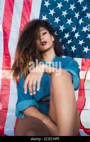 Young Woman sitting near flag of America Stock Photo