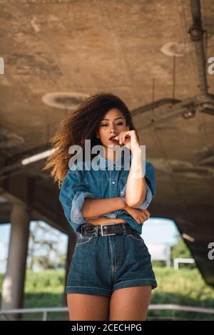 Young Woman standing under bridge Stock Photo