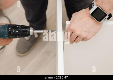 Installation and adjusting fixing kitchen cabinet door hinge adjustment Stock Photo