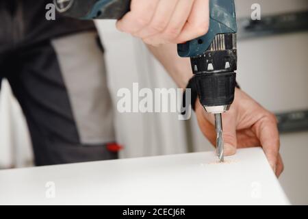 Installation and adjusting fixing kitchen cabinet door hinge adjustment Stock Photo