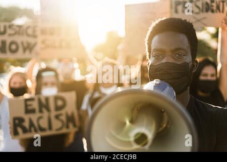 People from different culture and races protest on the street for equal rights - Demonstrators wearing face masks during black lives matter fight camp Stock Photo