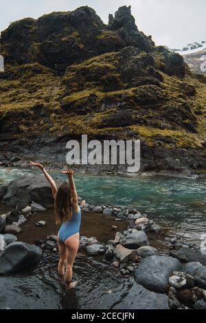 Young Woman standing in mountain river Stock Photo