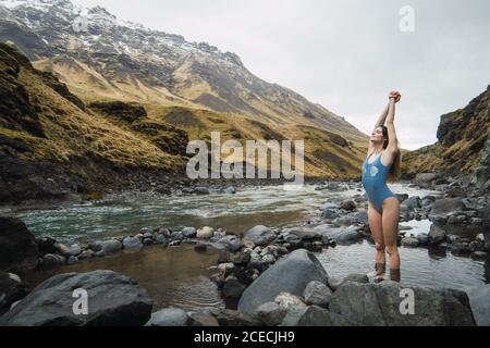Young Woman standing in mountain river Stock Photo
