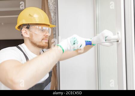 Worker in installing white plastic upvc window on house Stock Photo