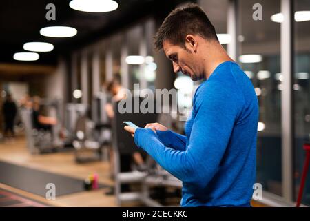 man using mobile phone in gym Stock Photo