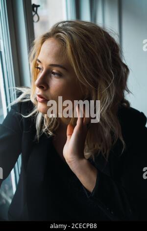 Romantic Woman posing on windowsill Stock Photo