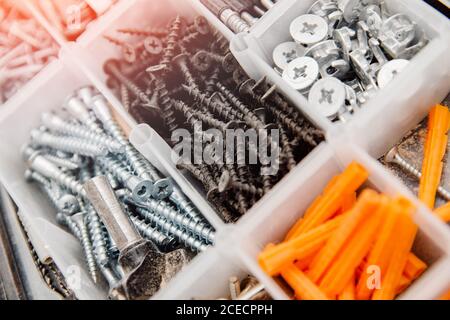 Case with small construction objects. Set metal tool box of screws, anchors, nails, bolts Stock Photo